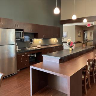 A modern kitchen with stainless steel appliances and wooden furnishings.