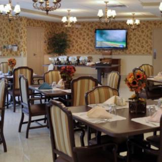 A cozy restaurant dining area with elegantly set tables, chairs, and warm decor.