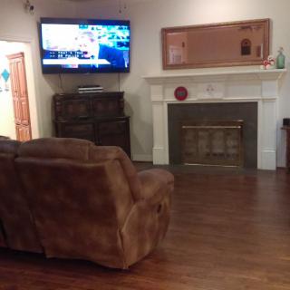 Cozy living room with a wall-mounted TV and a comfortable sofa.