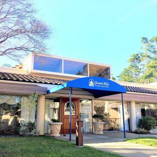 An entrance to a building with a blue awning and glass doors.