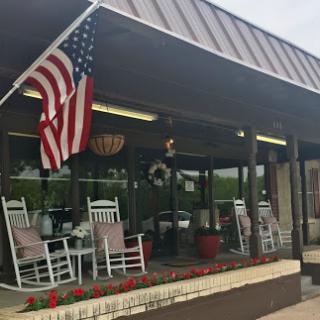 A cozy and inviting porch with rocking chairs, adorned with an American flag.
