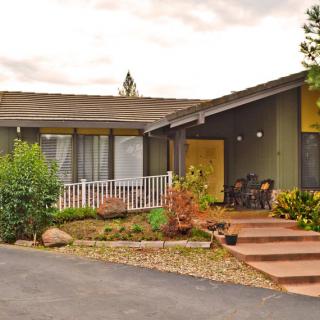 A suburban house with a porch and landscaped garden.