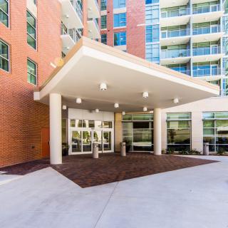 A modern apartment building entrance with a covered portico and glass doors.