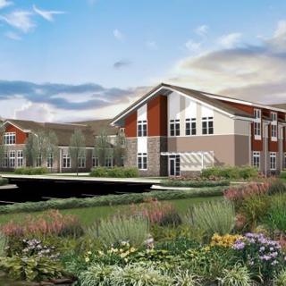 A modern residential building surrounded by a lush, landscaped garden.