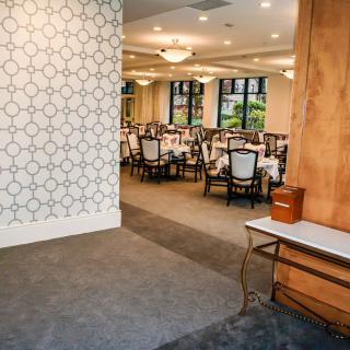A well-appointed dining area with elegant tables and chairs set for guests, featuring stylish lighting and decor.