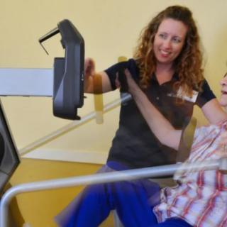 A physical therapist assists a patient with a rehabilitation exercise machine.