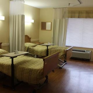 A hospital room with twin beds separated by privacy curtains.