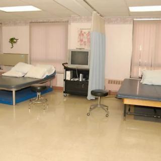 A physical therapy room with beds and medical equipment.