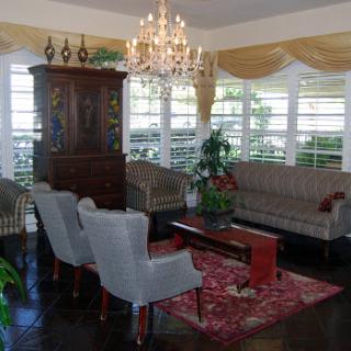 A stylish living room featuring elegant furniture, a chandelier, and decorative elements.