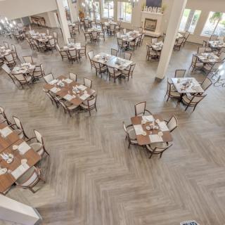 An empty restaurant dining area with neatly arranged tables and chairs.