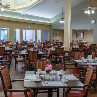 An empty dining room with neatly arranged tables and chairs, ready for guests.
