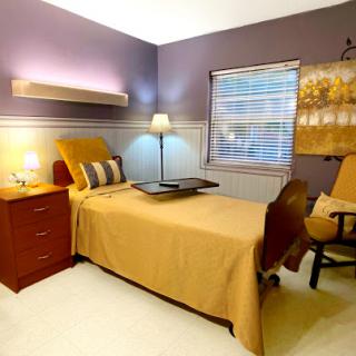 A cozy and modern bedroom featuring a comfortable bed, stylish armchair, and warm lighting.