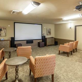 A cozy home theater with comfortable seating and a large projector screen.