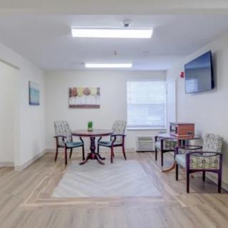 A cozy and well-lit small meeting area with tables and chairs.