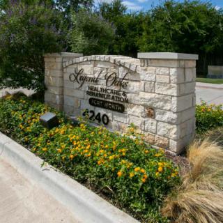 Entrance sign for a residential or commercial area with landscaping and flowers.