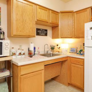 A cozy kitchen featuring wooden cabinets, a functional countertop, and essential appliances.