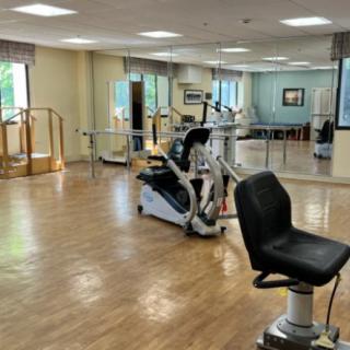 A spacious gym with exercise equipment and large mirrors.