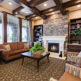 A cozy living room featuring a stone fireplace, comfortable seating, and elegant decor.