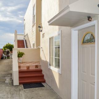 A view of a house entrance with stairs leading up to a higher level.