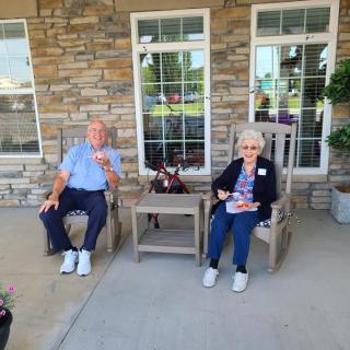 Two elderly individuals sitting outside, enjoying a relaxing moment.