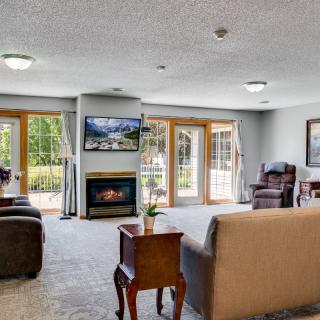 A spacious living room with comfortable seating, a fireplace, and large windows letting in natural light.