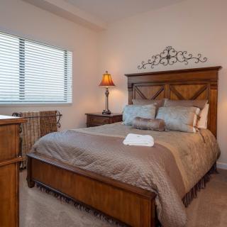 A cozy bedroom with a wooden bed frame and warm lighting.