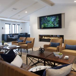 A modern living room featuring comfortable seating, a sleek fireplace, and a large television.