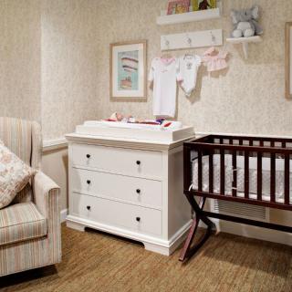 Cozy nursery with a crib, changing table, and comfortable armchair.
