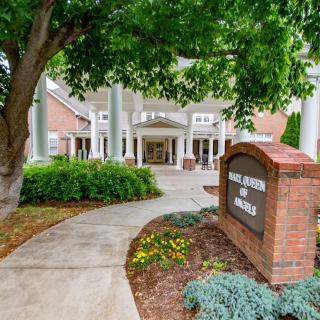 A welcoming building entrance surrounded by greenery and a clear pathway.