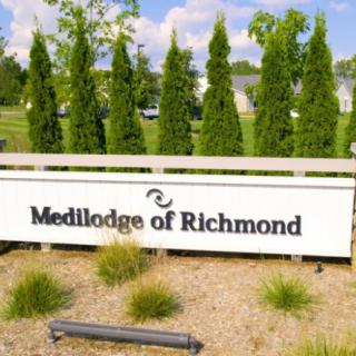 A sign for Medilodge of Richmond surrounded by trees and landscaping.