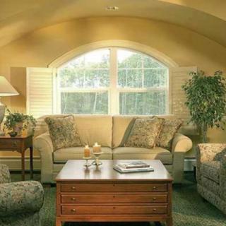 A cozy living room with a sofa and coffee table near a large window.