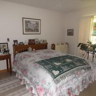 A cozy bedroom with floral bedding and decorative items.