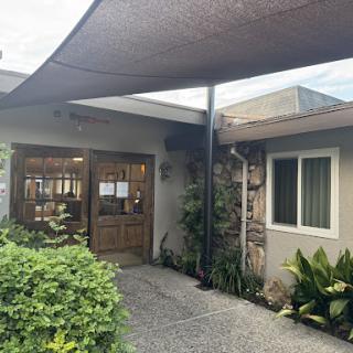 A welcoming entrance featuring a shaded walkway and lush greenery.