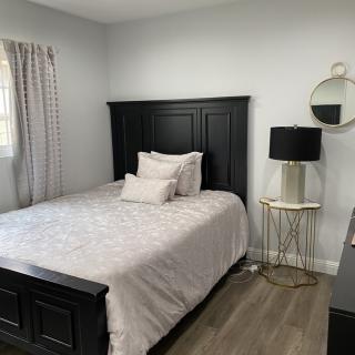 A cozy bedroom with a dark wooden bed frame and modern decor.