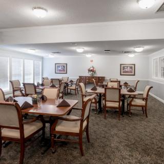 A spacious dining room with neatly arranged tables and chairs, featuring elegant decor.