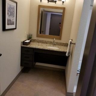 A well-organized bathroom with a wall-mounted mirror and sink.