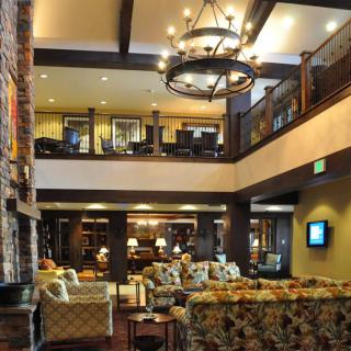 A spacious hotel lobby featuring cozy seating and a large chandelier.