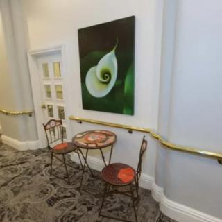 A cozy hallway corner with a small table, two chairs, and artwork on the wall.