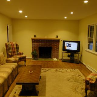 A cozy living room with a sofa, table, fireplace, and television.