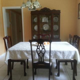 A classic dining room with a table, chairs, and a china cabinet.