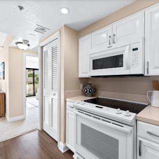 A modern kitchen featuring white cabinetry, a microwave, and a sleek stove.