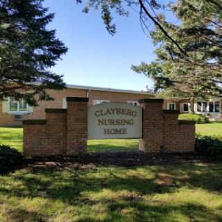 The entrance sign of Claybrook Center, surrounded by trees and greenery.