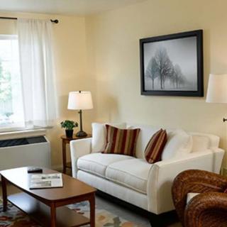 A cozy living room with a white sofa, framed artwork, and a coffee table.
