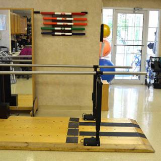 A physical therapy studio equipped with a barre and various exercise tools for rehabilitation and fitness.