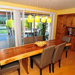 A cozy dining room with a large wooden table and modern pendant lights.