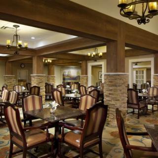 A well-appointed restaurant dining area featuring wooden furniture and elegant lighting.