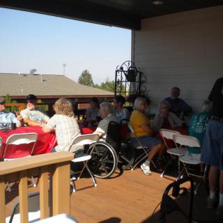 A group of people gathered outdoors on a patio, enjoying a social event.