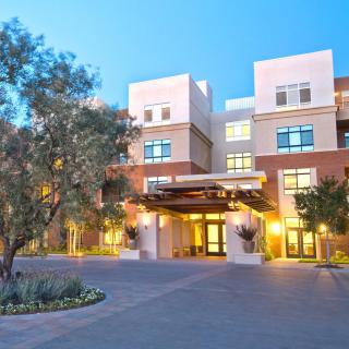 A modern hotel building with landscaped surroundings and a well-lit entrance.