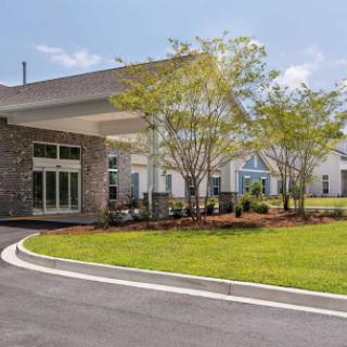 A modern healthcare facility surrounded by landscaped grounds.