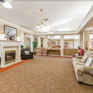A cozy living room with a fireplace, sofas, and elegant lighting.